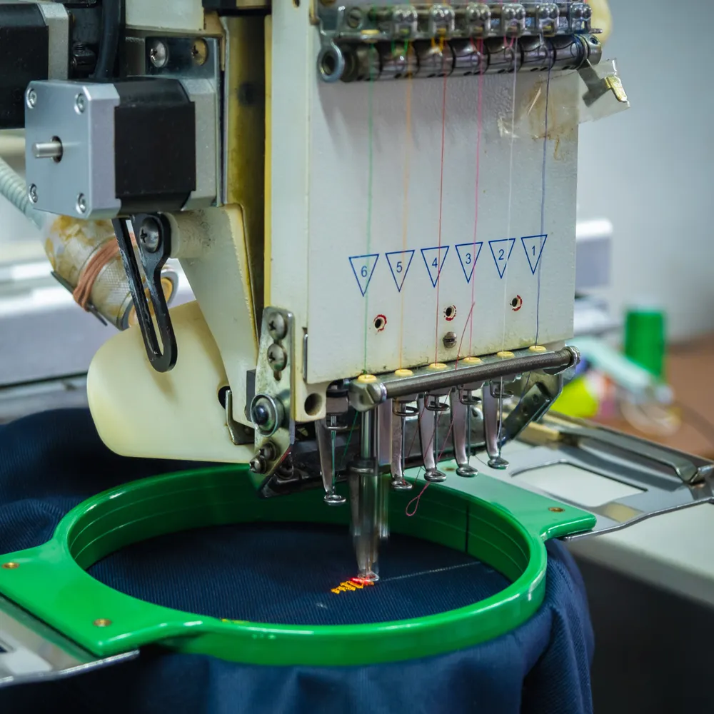 Multi-head embroidery machine stitching a logo