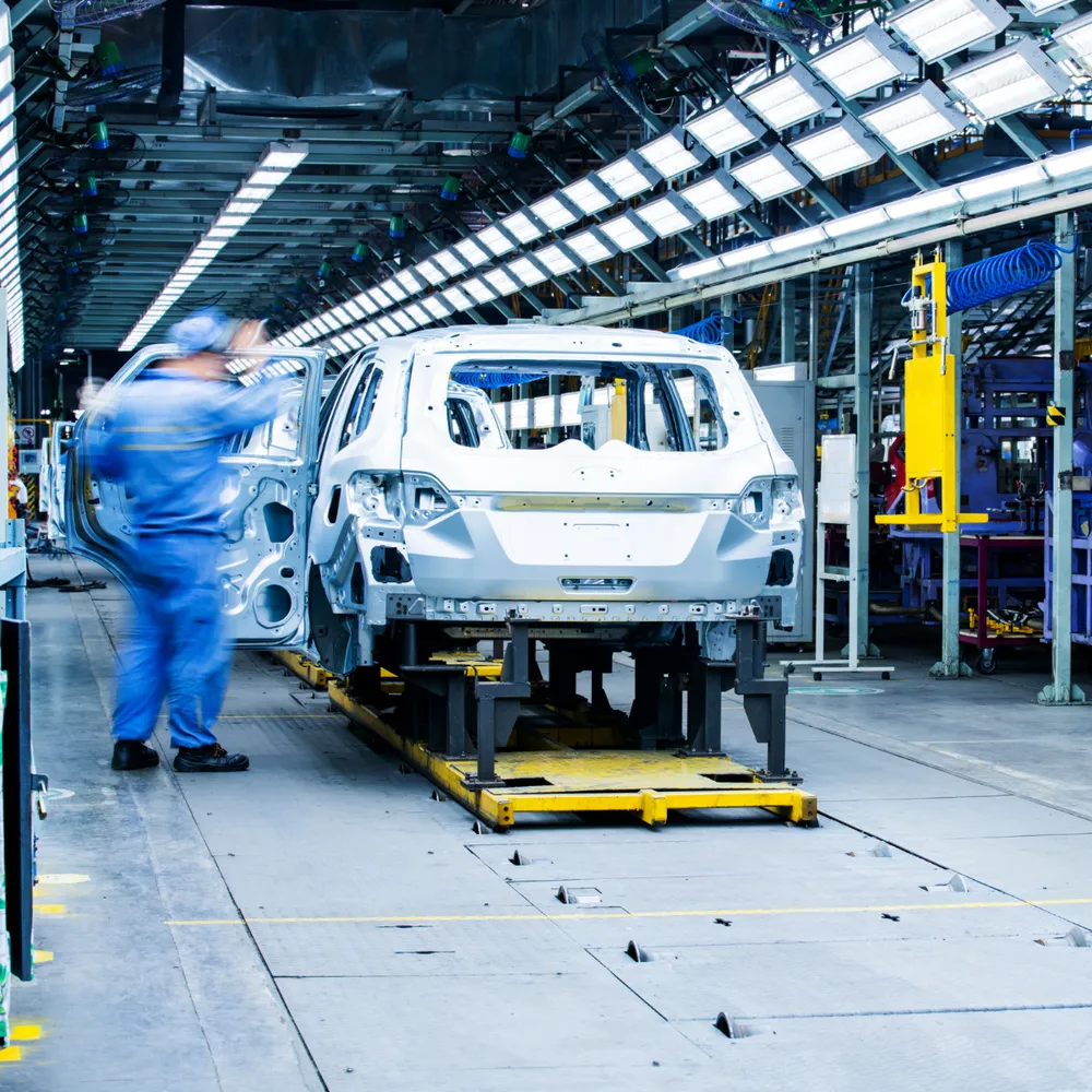 Operative in coveralls on a vehicle assembly line