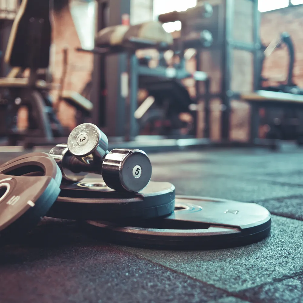 Dumbbells and weight plates on a rubber gym floor