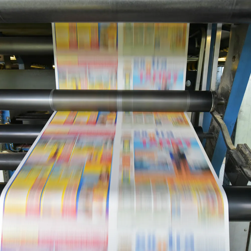 Colour print run moving through the rollers of a web printing press