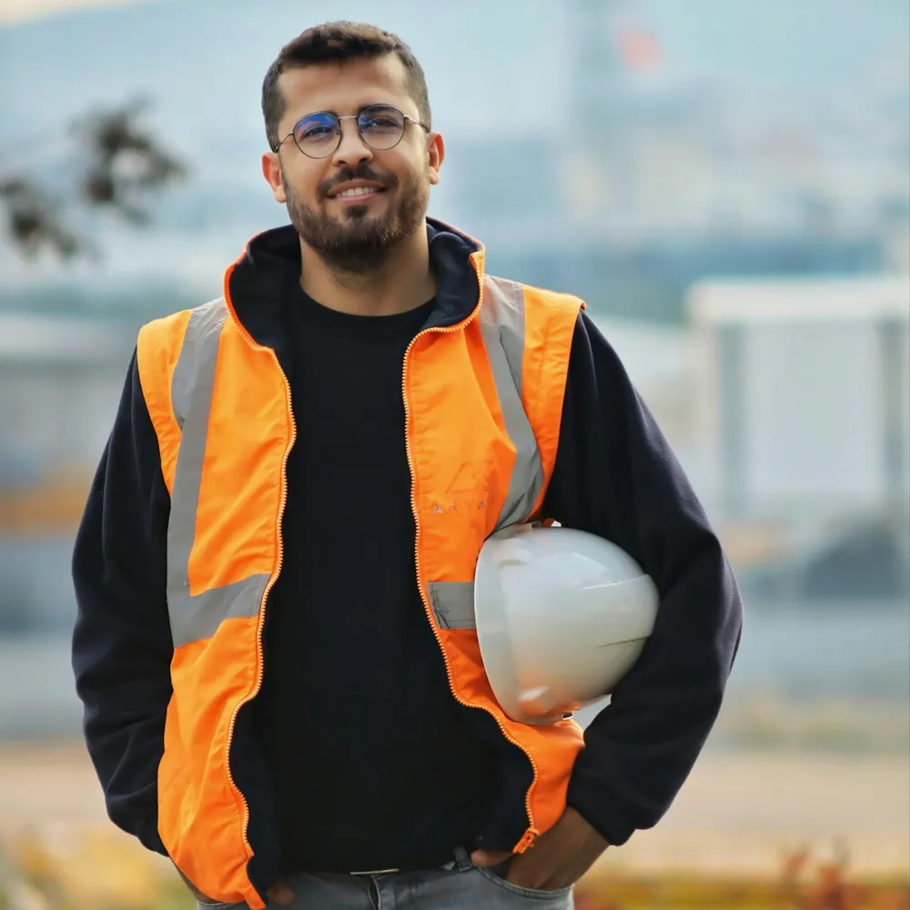 Tradesperson in orange hi-vis gilet and white safety helmet