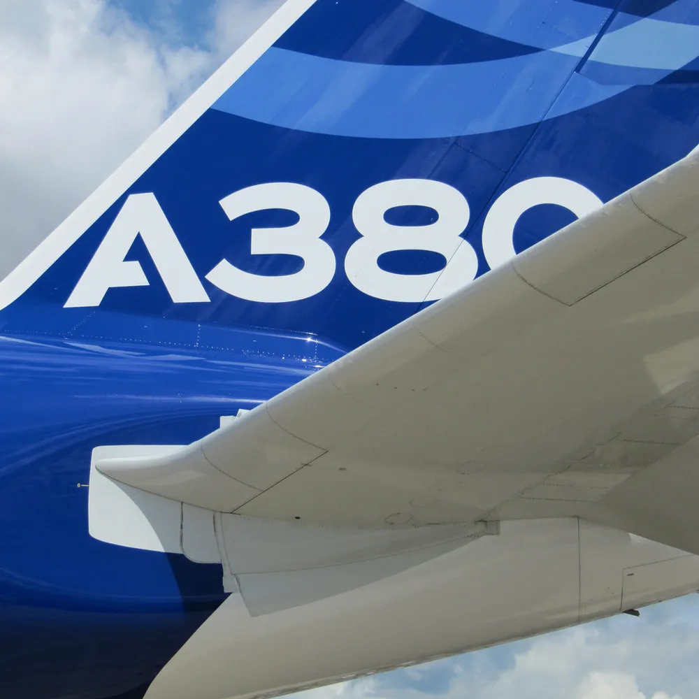 Airliner tail fin and wing against the sky