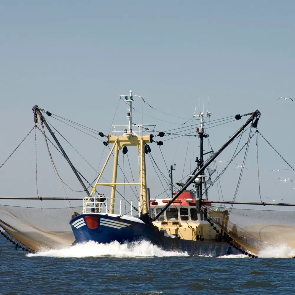 Fishing trawler under way with nets rigged
