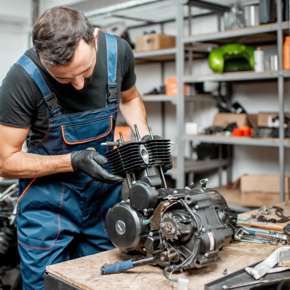 Engineer in bib and brace working on an engine