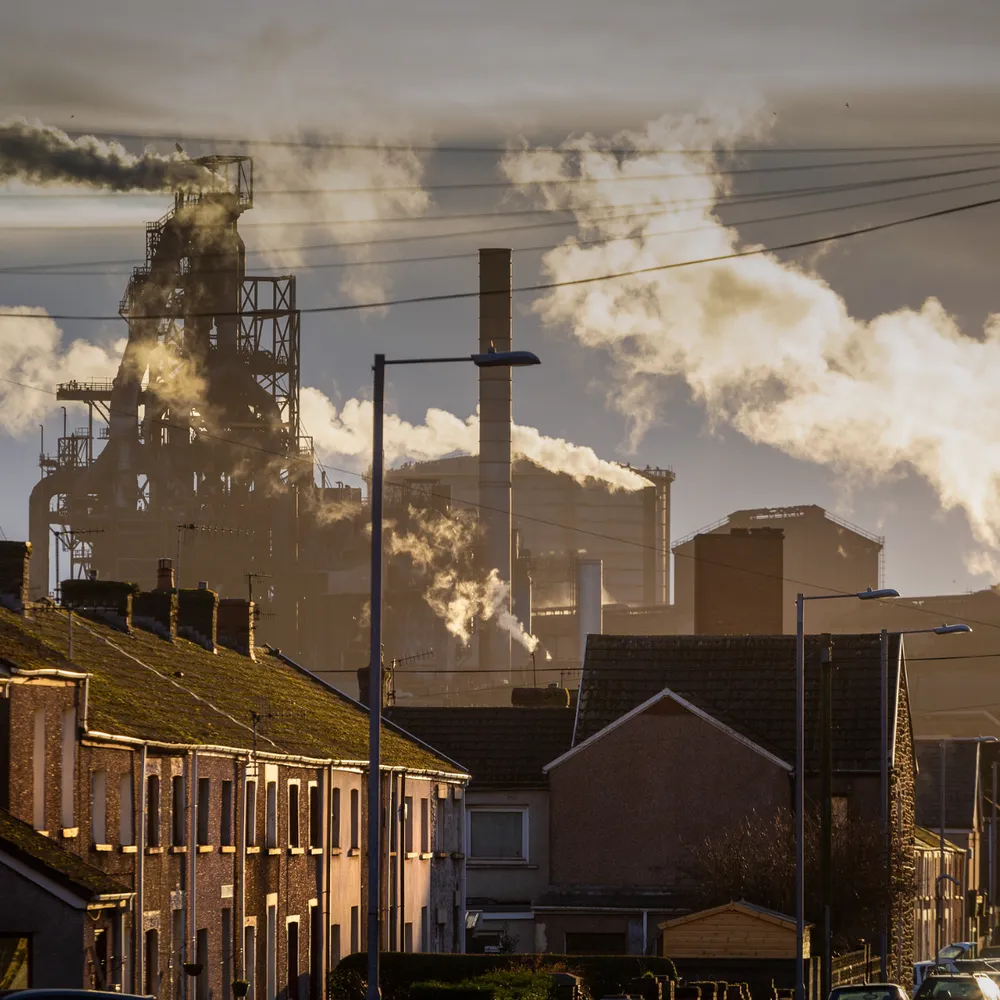 Steelworks rising behind terraced streets at sunset
